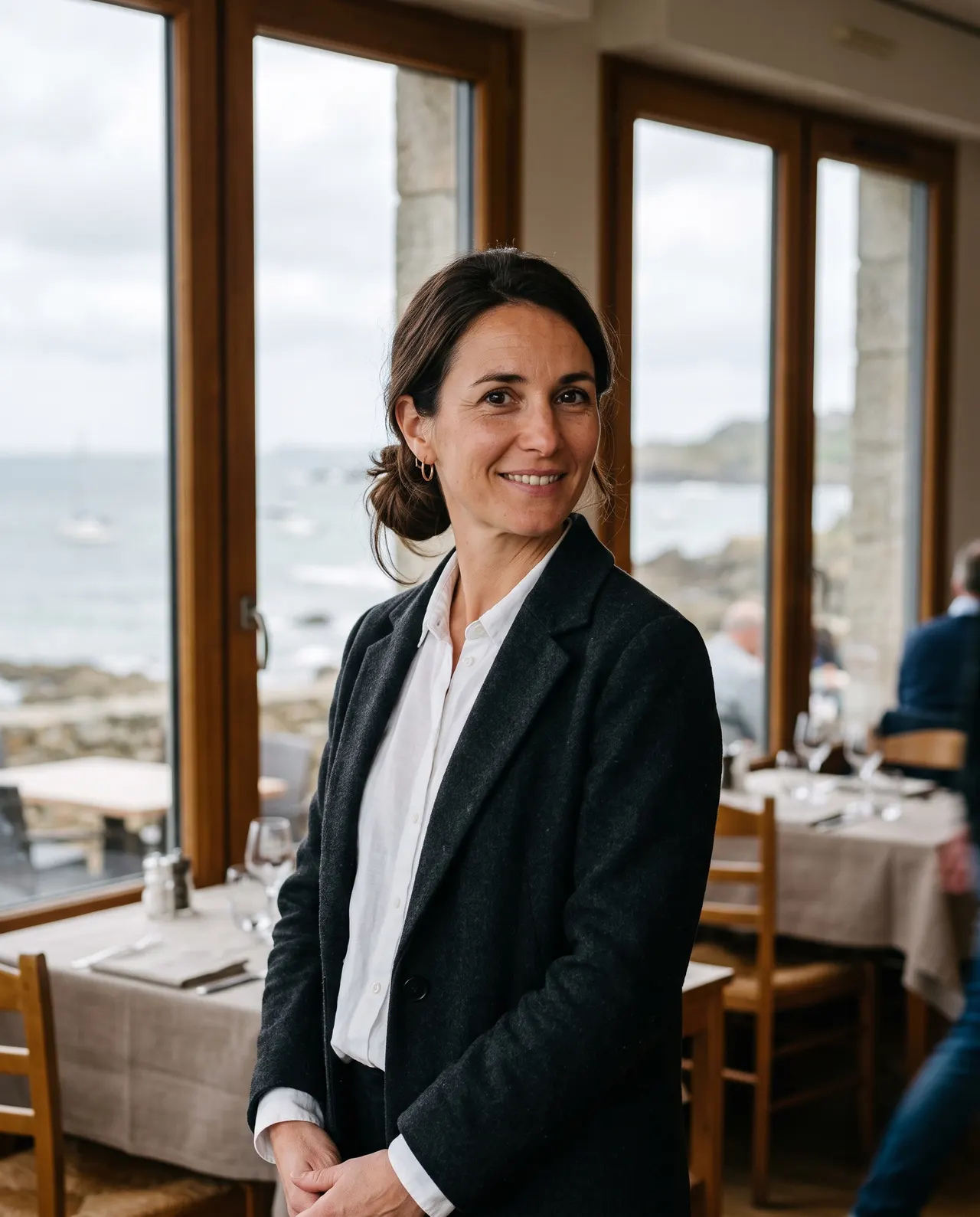 Margaux Hochart, directrice de salle, devant les baies vitrées de la salle face à la mer